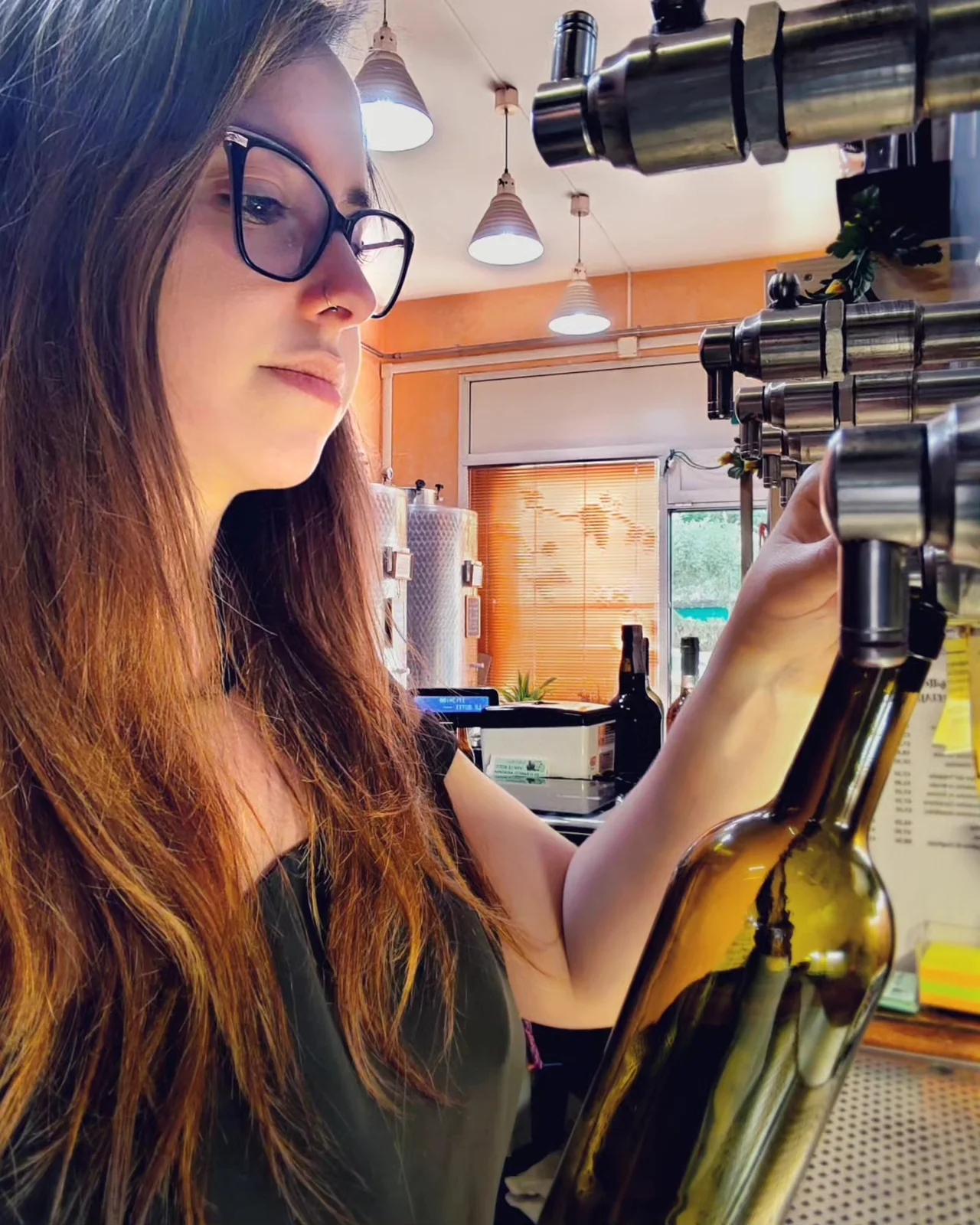 Arianna al lavoro, mentre prepara una bottiglia di vino in enoteca
