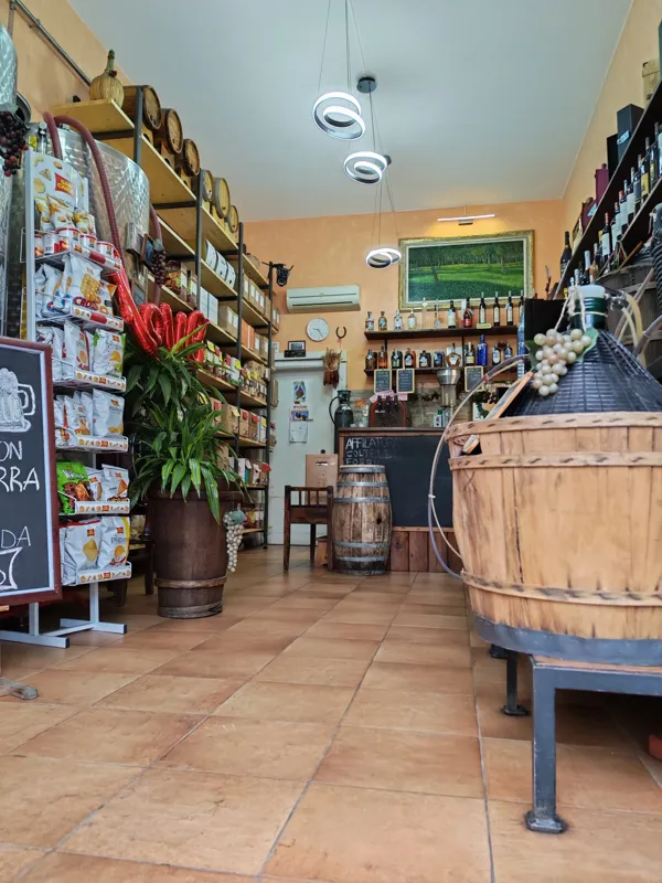 L’interno accogliente dell’enoteca, con la botte e gli scaffali